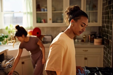 Couple cleaning up a kitchen listening to a Bose Bluetooth speaker.
